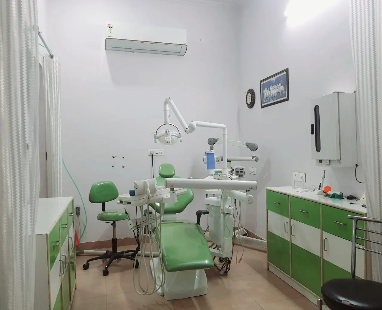 The dental operatory at Devkripa Healthcare with a green dental chair